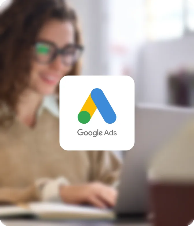 Dame an einem Laptop mit Brille – Google Ads Logo im Vordergrund